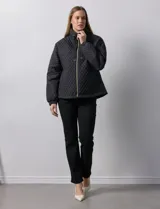 Campera beige capitoneada con capucha, cierre frontal y bolsillos laterales.