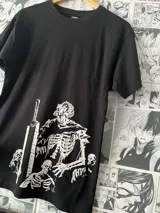 Remera negra de manga corta con estampado de esqueleto con espada y zombies en color blanco. Estampado en vinilo textil.