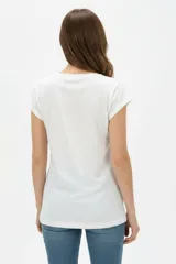 Remera de algodón blanca, de corte holgado, manga corta con vuelta y cuello redondo. Cuenta con un estampado frontal abstracto con trazos en tonos marrón y foil dorado.