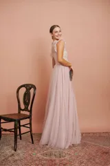 Vestido largo de tul plumetí en color rosa suave, con detalles de encaje bordado en el torso y volados en los hombros.