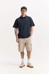 Bermuda cargo color beige de corte relajado, con bolsillos al frente, bolsillos cargo laterales y cintura con pasadores, largo a la rodilla.