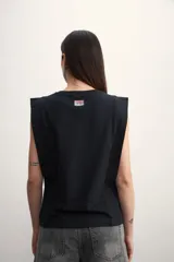Remera musculosa negra con hombreras marcadas y cuello redondo.
