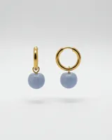 Par de aros tipo argolla de acero dorado con dije colgante de piedra natural en color celeste.