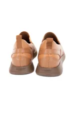 Zapato slip-on de cuero vacuno color caramelo con textura delicada, inserciones elásticas laterales y suela flexible.