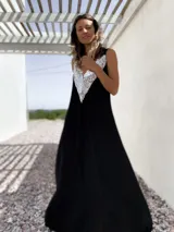 Vestido largo de fiesta color negro, con escote en V profundo decorado con lentejuelas plateadas y breteles anchos.