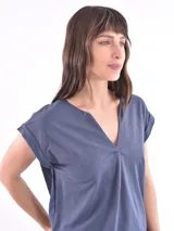 Blusa blanca de corte holgado, con cuello en V y mangas cortas.