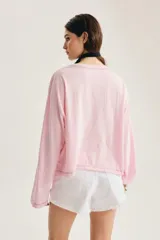 Remera de manga larga gris oscuro con efecto lavado gastado, corte oversize y cuello redondo amplio. Cuenta con estampado tipográfico manuscrito en el pecho.