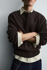 Jersey de corte relajado confeccionado en tejido de algodón. Presenta cuello redondo, manga larga y acabados en rib en puños, cuello y bajo.