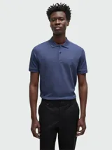 Polo de manga corta color azul marino, confeccionado en tejido piqué de algodón, con cuello y tapeta de dos botones. Presenta un logo bordado sutil en el pecho.