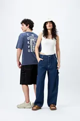 Pantalón jean negro de corte amplio y estilo carpenter, con tiro medio, bolsillos utilitarios y presillas laterales.