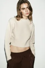 Jersey de punto suave con cuello redondo y manga larga, con terminaciones en rib en puños, cuello y ruedo.