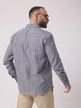 Camisa de hombre de manga larga con rayas verticales en tonos verde claro y blanco. Confeccionada en una mezcla de lino y algodón, presenta cuello abotonado y bolsillo en el pecho.