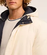 Campera puffer de hombre reversible, con diseño acolchado, cuello alto, capucha y cierre frontal.