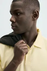 Polo de hombre color verde oliva, de corte regular fit, con cuello solapa y cierre frontal de botonadura. Presenta manga corta y acabados en rib.