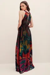 Vestido largo con cuello halter y escote cerrado, con diseño plisado y estampado multicolor con detalles abstractos y florales. Presenta un aplique bordado decorativo en la cintura.