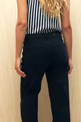 Jean de corte recto confeccionado en denim con spandex, de tiro medio y color azul claro. Presenta un tajo lateral en el ruedo de ambas piernas.