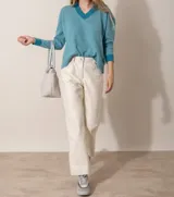 Pantalón de cuero ovino italiano color crema, de corte recto con tajos laterales en el ruedo.