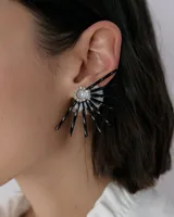 Caravanas tipo medio sol con diseño de rayos en resina negra y base transparente, decoradas con un centro circular de strass brillante.