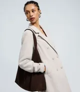 Saco largo de corte recto confeccionado en polivelour, con cuello de solapas, cierre frontal con botones y bolsillos laterales. Presenta un diseño elegante y funcional, ideal para la temporada de invierno.