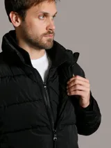 Campera acolchada Calvin Klein de color negro, con diseño matelasseado, cuello alto, cierre frontal con cremallera y bolsillos laterales con cierre. Incluye chaleco interior desmontable.