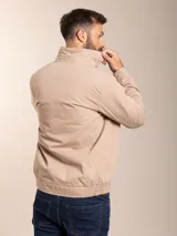 Campera azul marino con cierre frontal, cuello camisero y logo bordado en el pecho.