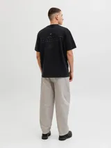 Remera negra de manga corta con cuello redondo y calce relajado, confeccionada en tejido de punto interlock con sutil estampado frontal.