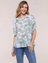 Camisa de lino sintético con estampado floral en tonos azules y beige sobre fondo blanco, de corte holgado, mangas tres cuartos y cuello camisero.