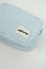 Neceser de diseño acolchado en color celeste, con cierre superior y etiqueta frontal con el logo de la marca.