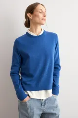 Sweater clásico de punto color beige, de cuello redondo y manga larga con diseño ajustado.