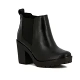 Bota tipo Chelsea de cuero negro con paneles elásticos laterales, taco cuadrado y suela con plataforma dentada.