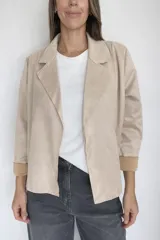 Chaqueta corta de diseño abierto sin cierre, confeccionada en tejido con textura efecto ante. Presenta solapas clásicas, mangas largas con puños vueltos y un corte recto y holgado.