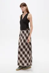 Falda midi de algodón con estampado a cuadros en tonos marrón, beige, gris y blanco, de corte amplio y fluido.
