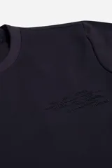 Remera de manga larga color negro con textura micro y gráfica frontal en relieve con diseño tipográfico. Presenta cuello redondo y corte regular.