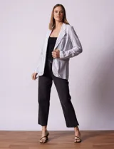 Blazer blanco con rayas verticales negras, cuello con solapa, abertura central con botón y bolsillos delanteros.