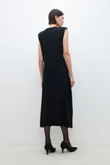 Vestido midi negro de tejido de punto, sin mangas, con cuello redondo y hombreras.
