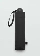 Paraguas plegable de diseño liso en color negro, con correa de mano y etiqueta metálica con logo en el lateral.