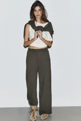 Pantalón de tiro medio con pierna ancha, confeccionado en tejido lavado. Presenta cintura elástica ajustable con cordones, bolsillos laterales y bolsillos traseros decorados con estrellas y aplicaciones de tachas. El diseño cuenta con terminaciones desflecadas en el ruedo.