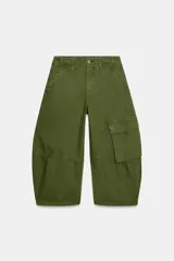 Jeans capri de tiro medio y diseño balloon leg, color verde militar, con bolsillos laterales y bolsillo cargo en la pierna. Cuenta con trabillas para cinturón y cierre frontal con cremallera y botón metálico.