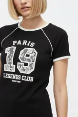 Remera de algodón blanca de manga corta estilo ringer, con cuello y puños en contraste negro. Presenta un estampado frontal con el número '28' relleno de encaje y la inscripción 'San Francisco Sports Club'.