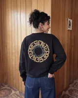 Buzo de cuello redondo color negro, con estampado circular en la espalda que presenta la palabra 'PRESENTE' en tipografía gótica de color beige y gris. Cuenta con puños y cintura acanalados.