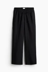 Pantalón negro de corte holgado y piernas anchas, confeccionado en mezcla de lino y viscosa. Cuenta con tiro bajo, cintura elástica con cordón ajustable y bolsillos laterales discretos.