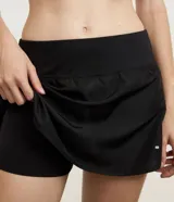 Short pollera deportivo de color negro, confeccionado en poliéster. Presenta cintura elástica, un pequeño bolsillo funcional y detalles de recortes laterales en red.