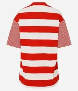 Remera de algodón con cuello redondo, cuerpo a rayas horizontales anchas rojas y blancas, y mangas cortas con rayas horizontales finas rojas y blancas. Presenta sisa desplazada y costuras aparentes.