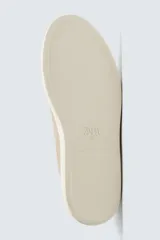 Zapatilla urbana de hombre confeccionada en piel con acabado de serraje, diseño minimalista con cordonera oculta y suela de goma a contraste.