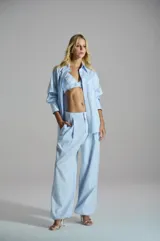 Pantalón ancho de mujer con estampa de rayas celestes y blancas, tiro alto y bolsillos laterales.