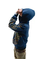 Hoodie azul con cierre y bolsillos laterales, con estampado dorado de hojas de acanto en el frente y las mangas.