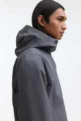 Campera rompevientos de nylon repelente al agua, con capucha ajustable, cierre frontal completo, bolsillos laterales y puños elásticos.