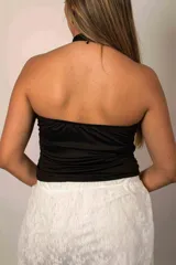 Top halter blanco con fruncidos en el centro y escote pronunciado.