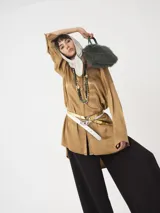 Camisa amplia color blanco, de textura arrugada, con laterales abiertos y detalle de tabla en la espalda.