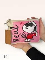 Sobre de cuero marrón con diseño pintado a mano que presenta al personaje Snoopy sobre un fondo rosado y la palabra 'heal'. Cuenta con cierre superior y etiqueta de cuero colgante.